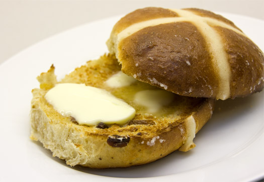 a finished, toasted hot cross bun with butter