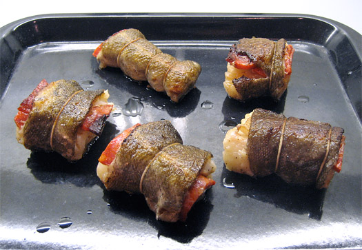 the fried, portioned cod on a baking tray